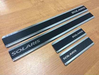 1 679 р. Пороги накладки Russtal  Hyundai Solaris ( 1 седан,  1 хэтчбек) (2010-2014) (Нержавейка с покрытием карбон и надписью). Увеличить фотографию 1